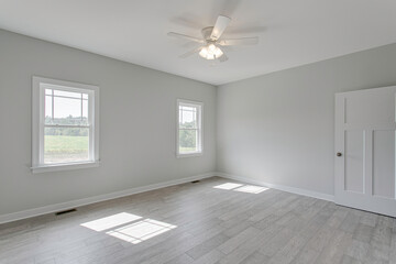 Light-Filled Room With Ceiling Fan And Wooden Flooring