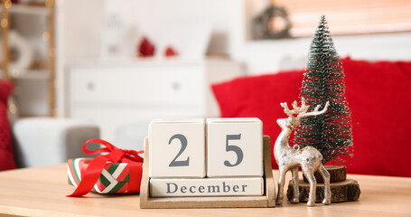 Cube calendar with date of Christmas, decor and gift on table in living room