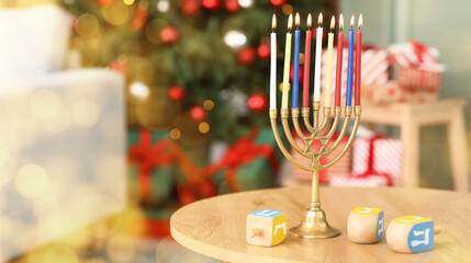 Menorah with burning candles and dreidels for Hanukkah celebration on table in living room, closeup