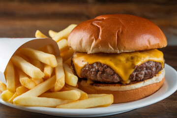 Cheeseburger with thick cut fries on a white gourmet dinner plate. Gourmet food photography.