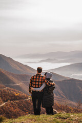 Obraz premium A happy couple who hikers enjoys a break look at the top of the mountain adventure travel space for text.