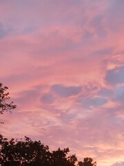 A mesmerizing sunset sky ablaze with pink hues, where soft clouds create an awe-inspiring backdrop that evokes wonder and peaceful reflection amid nature's art.