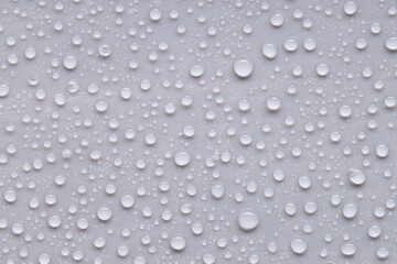 Water drops on gray background, top view