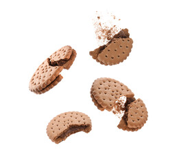 Tasty broken sandwich cookies in air on white background