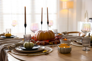 Naklejka premium Stylish table setting with beautiful dishware and autumn decor in dining room