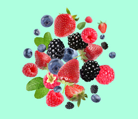 Mix of fresh berries in air on turquoise background