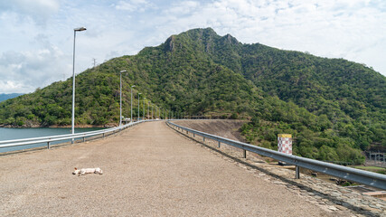 The road on the dam Background mountains and water