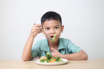Nutrition healthy eating habits for kids concept. Children do not like to eat vegetables. Little cute boy refuses to eat healthy vegetables.
