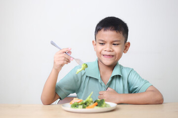 Nutrition healthy eating habits for kids concept. Children do not like to eat vegetables. Little cute boy refuses to eat healthy vegetables.