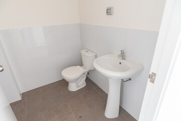 moderno baño de departamento con acabados en loza , lavabo e inodoro