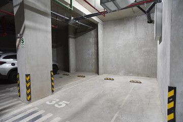 estacionamiento de edificio de departamentos en sotanos con acabados en cemento y demarcado