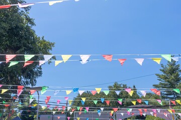 The colorful flags between the trees at a celebration event