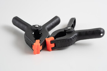 Obraz premium Two black plastic clamps. Equipment for handicraft, joinery and photography. isolated on white background