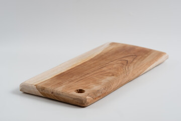 Food preparation tool and kitchen utensils concept with close-up on rectangular wood chopping board with round corners isolated on white background at an angle perspective with clipping path cutout