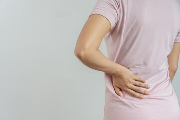 woman holding her lower back while and suffer from unbearable pain health and problems, chronic...