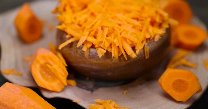 grated carrots on the table during cooking, sweet ripe orange carrots peeled, washed and grated into small pieces