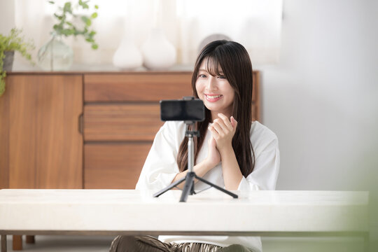撮影する動画配信者のイメージ　投げ銭ありがとう～かわいい若い女性がカメラに向けて御礼するファンサービス