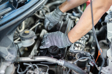 Mechanic's hands are inspecting the engine.