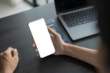 Hand Man Online booking and buying plane tickets using laptop phone and credit card Planning trip travel vacation with passport and ticket.