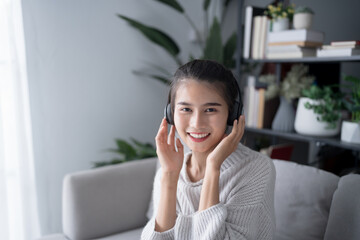 Asian beautiful woman smiling listen music at home in headphones Use technology lifestyle concept