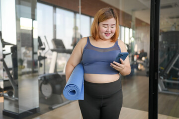 Fototapeta premium Obese asian woman diet holding yoga mat for training yoga&nbsp;exercising&nbsp;fitness workout and health concept. training working out at gym