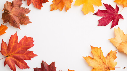 Colorful fall maple leaves form a decorative frame around a white backdrop, showcasing a spectrum of autumn tones from deep reds to golden yellows. The crisp white center contrasts beautifully with
