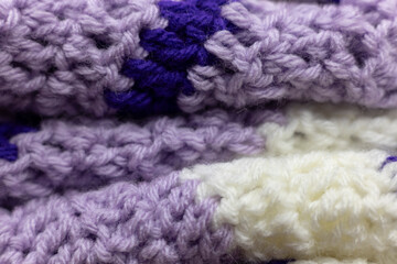 close-up of folded lilac purple zigzag blanket with white and royal purple accents, crocheted or knitted, reminds you of grandma's house, cozy and warm background