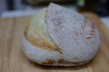 Freshly baked loaves of Sourdough bread displayed on a wooden table and board, showcasing a variety of textures and colors, perfect for a healthy breakfast or snack