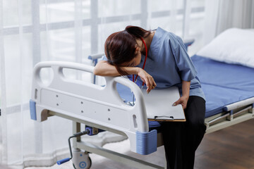 Obraz premium Medical nurse is on bed in hospital sitting down a the hospital corridor in frustration and grief after failure and patient body condition