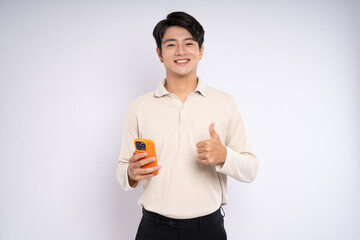 Portrait of young asian businessman wearing sweater and using phone on white background