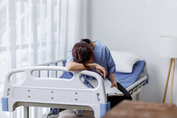 Medical nurse is on bed in hospital sitting down a the hospital corridor in frustration and grief...