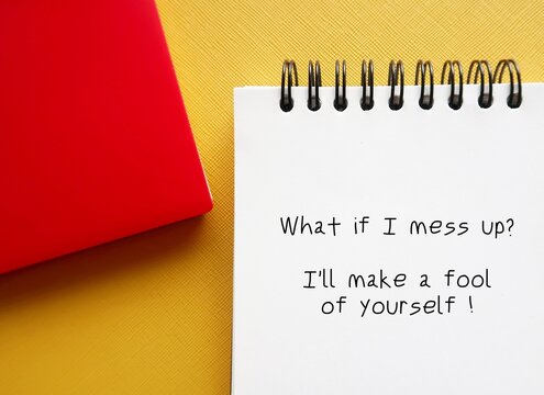 Notebook on yellow background written - What if I mess up? I'll make a fool of myself - Self-doubt - lack of confidence regarding oneself and abilities - feeling insecurity, awareness of one own limit