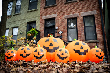 Halloween decorations on front door of house with pumpkins.
