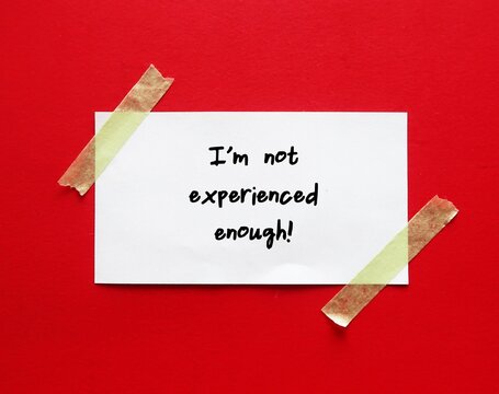 White paper stick on red background with text written - I am not experienced enough - Self-doubt - lack of confidence regarding oneself and abilities - feeling insecurity, awareness of one own limitat