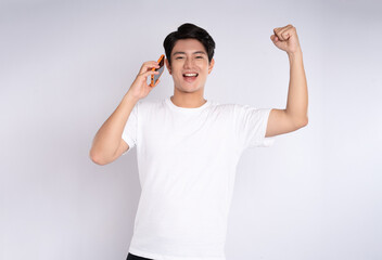 Fototapeta premium Portrait of young asian man using phone on white background 