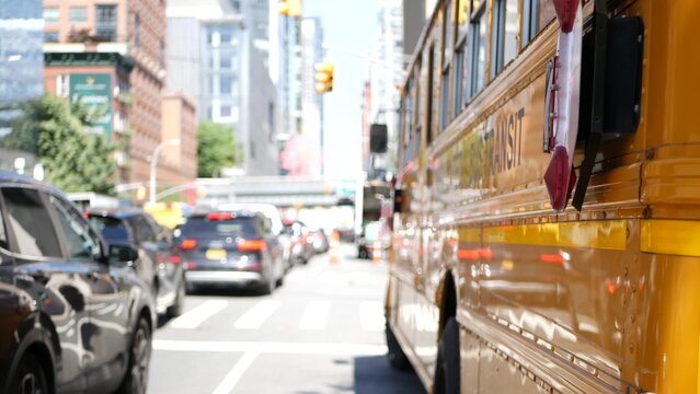 Yellow School Bus on New York Manhattan street, schoolbus truck on busy city road. Children education and transportation, USA. American school shuttle in traffic jam, 10 avenue Chelsea, United States.