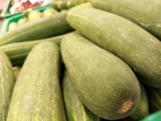 A close-up image of fresh green cucumbers with varying shades and patterns on their skins. Perfect for culinary, agricultural, or health-related projects.