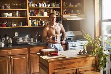 Happy, man and portrait with coffee in kitchen at morning with smile and confidence to start day. Relax, espresso and break in home with green tea for nutrition and health with person in underwear