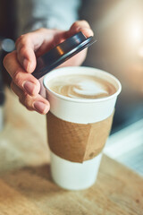 Hands, restaurant and person with takeaway coffee in morning with lid for beverage sale in cafe. Drink, paper container and closeup of customer with caffeine latte, cappuccino or espresso in store.