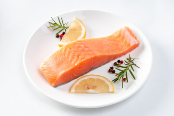 Juicy slice of fresh salmon with ingredients closeup isolated on a white background