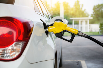 Transportation and ownership concept - man pumping gasoline fuel in car at gas station. hight price during war concept.