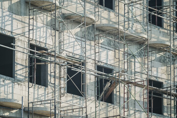 Extensive scaffolding providing platforms for work in progress on a new apartment block,Tall building under construction with scaffolds,Construction Site of New Building