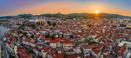 Obraz premium Sibenik, Croatia - Aerial view of the mediterranean old town of Sibenik on a sunny summer morning with Saint James Cathedral, Fortress of Saint Michael and dramatic golden sunrise by the Adriatic sea