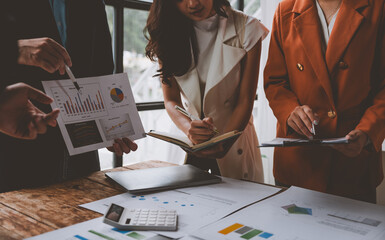 A team of male and female businessmen work together to inspect sales documents. Marketing analysis...