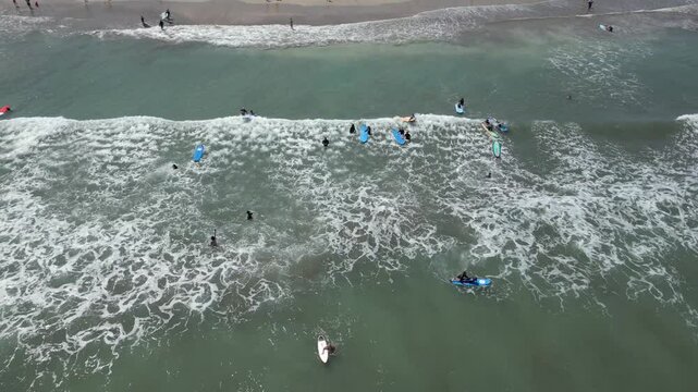 Aerial view of people taking surfing lessons in the ocean, Bali, Indonesia