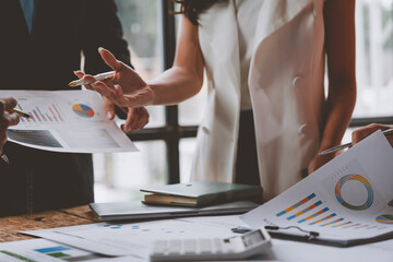 A team of male and female businessmen work together to inspect sales documents. Marketing analysis and action plans. Discuss financial analysis, sales management concepts.