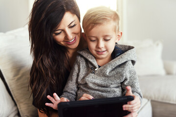 Tablet, relax and mom with kid on sofa for online videos, watching movies and playing games. Family, happy and mother and boy on digital tech for internet, educational website or cartoons in home