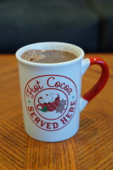 A cup of hot Cocoa, Hot Chocolate drink sits on a coffee table ready to be served.