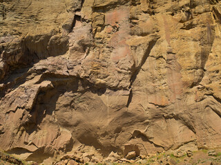 A rocky cliff with a few small rocks scattered around