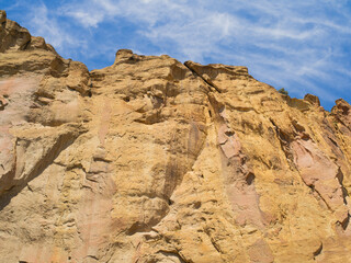 A rocky hillside with a blue sky in the background